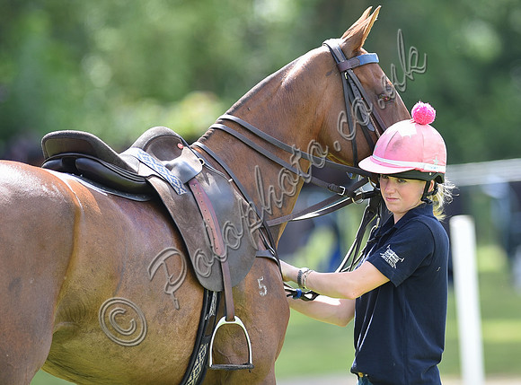 pony and female groom who is wearing pink helmet with pink bobble